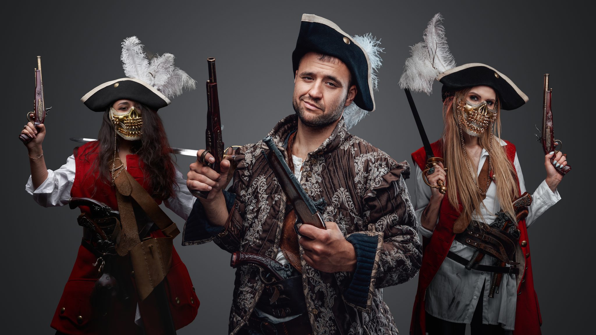 Buccaneer man with flintlock gun and two female pirates